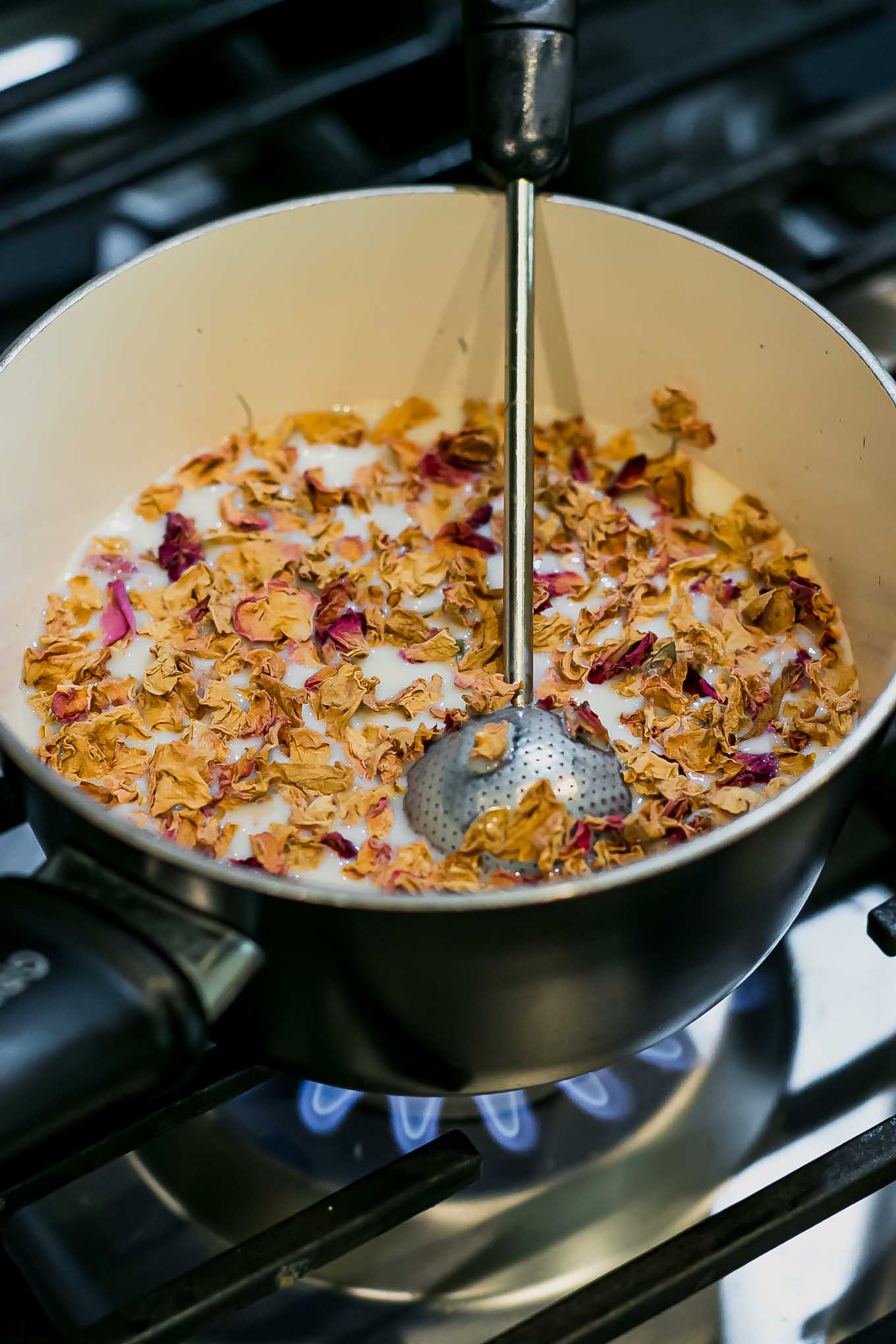 rose petals and chai tea infusing a saucepan on a stovetop