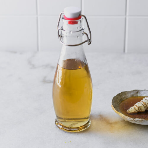 a jar of lavender and honey syrup on a white countertop