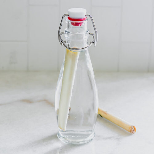 a glass jar with lemongrass simple syrup on a white countertop