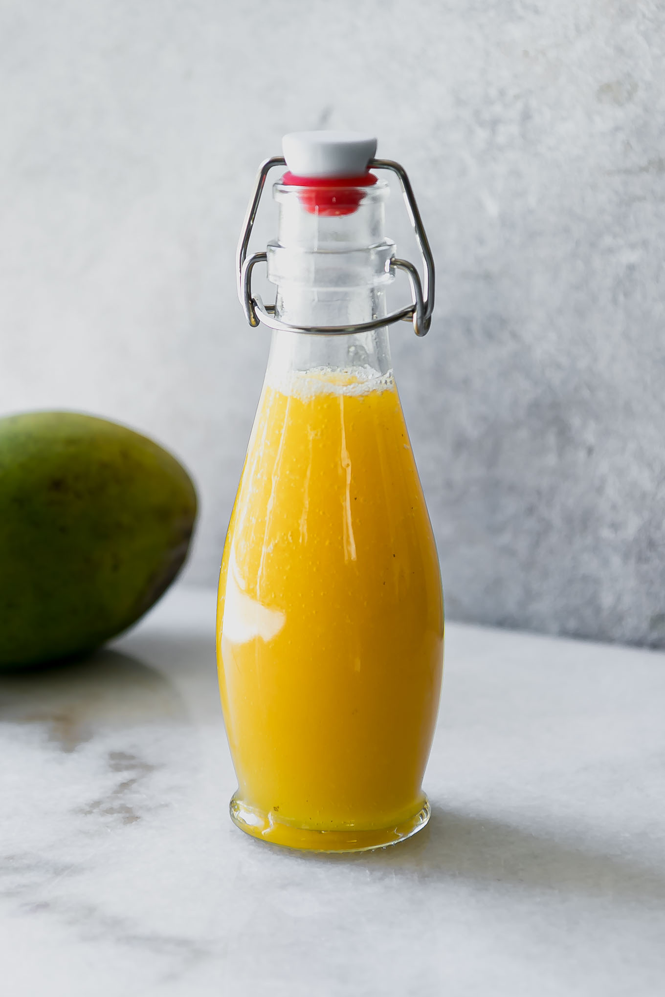 yellow mango infused syrup in a glass jar